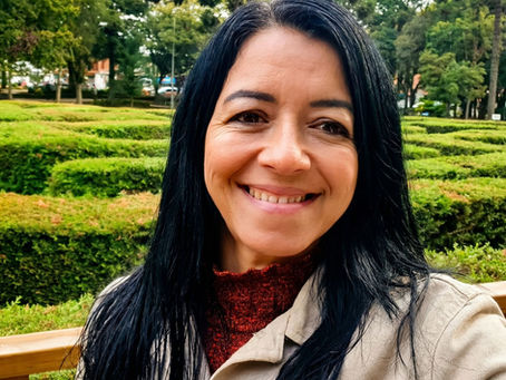 mulher sorrindo cabelos longos preto numa praça ao ar livre