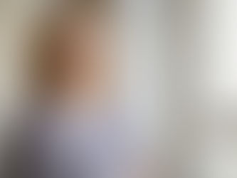 Mulher adulta loira olhando pela janela pensativa, representando a reflexão e a busca por compreensão no diagnóstico tardio do autismo em mulheres.