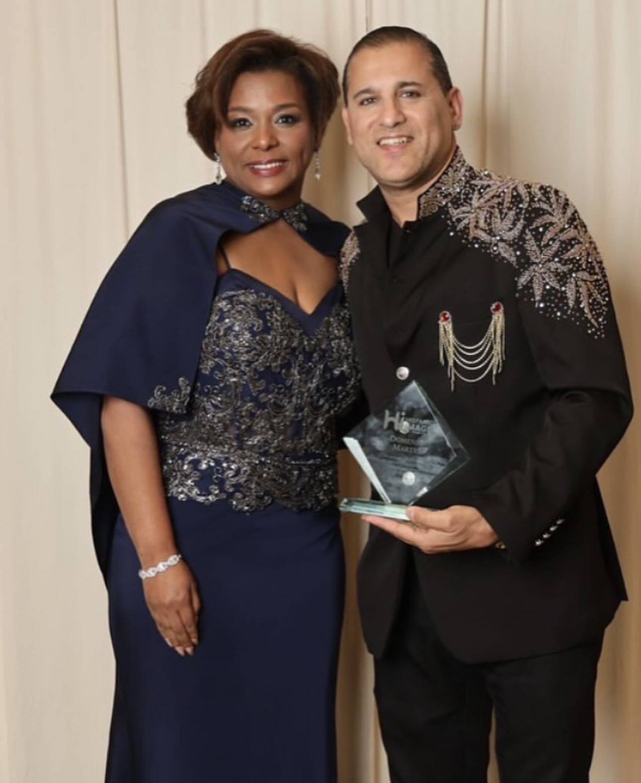 Domenic Marte con un premio de cristal, junto a otra persona