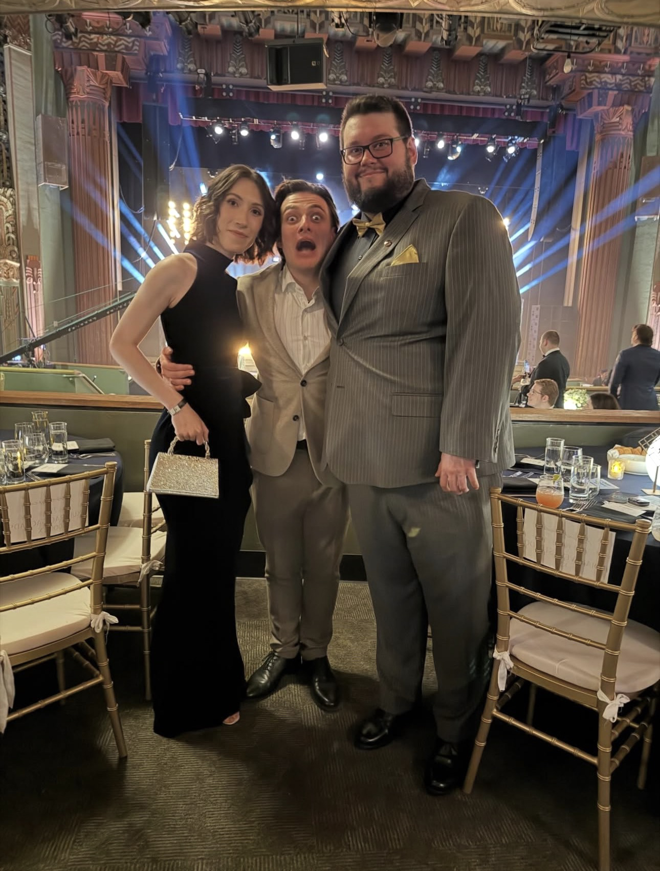 Flats, de traje, junto a otras dos personas en un evento