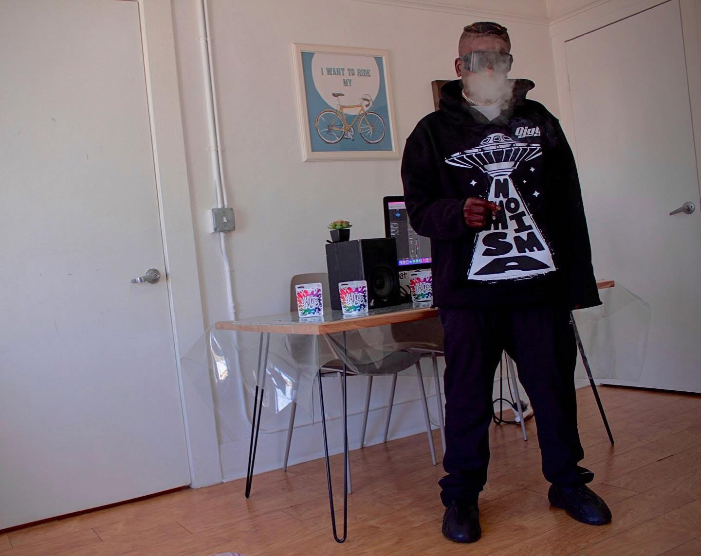 Trae Da Kidd de pie en una habitación con un monitor de estudio al fondo