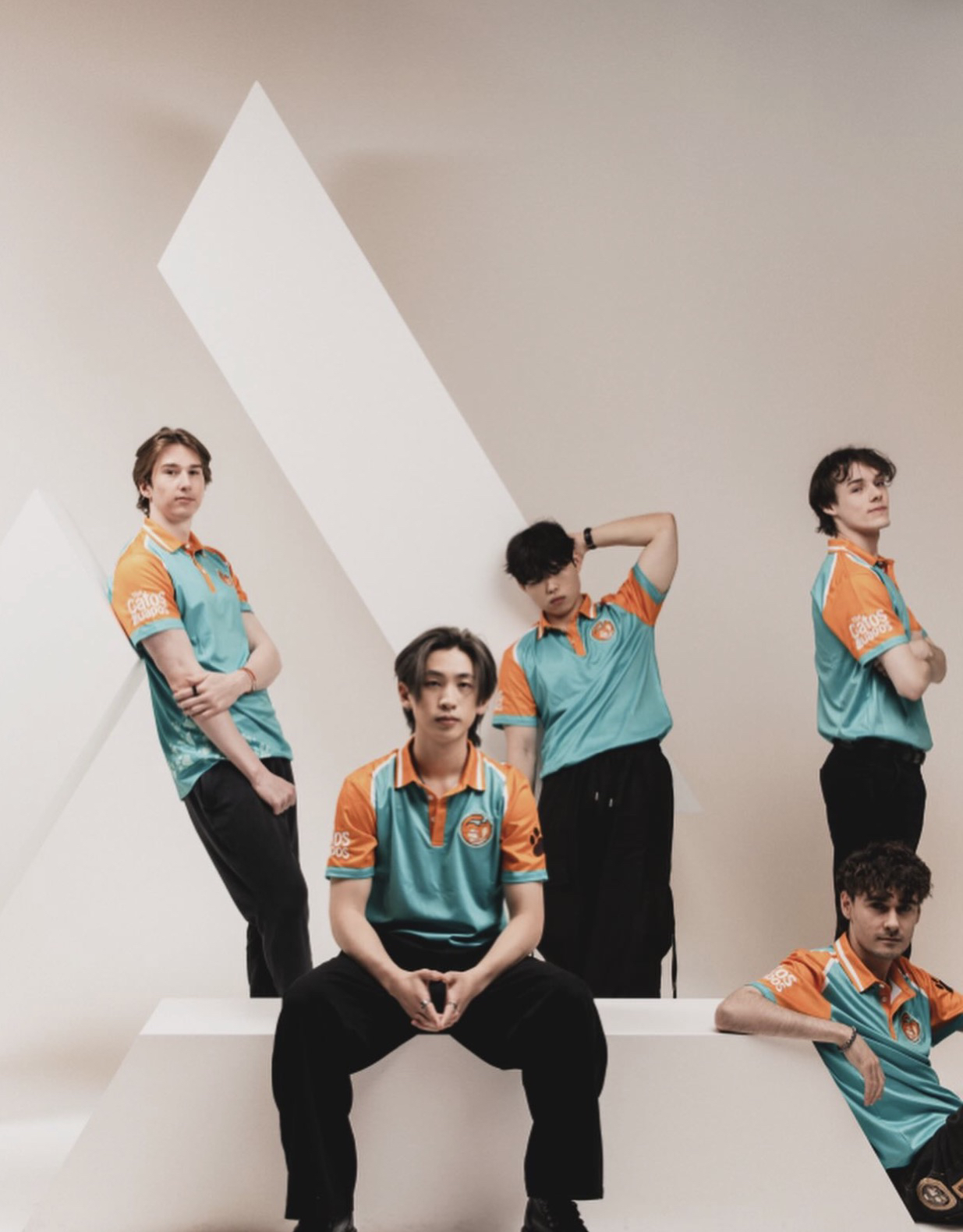 Cinco jugadores con camisetas turquesa y naranja posan sobre bloques blancos