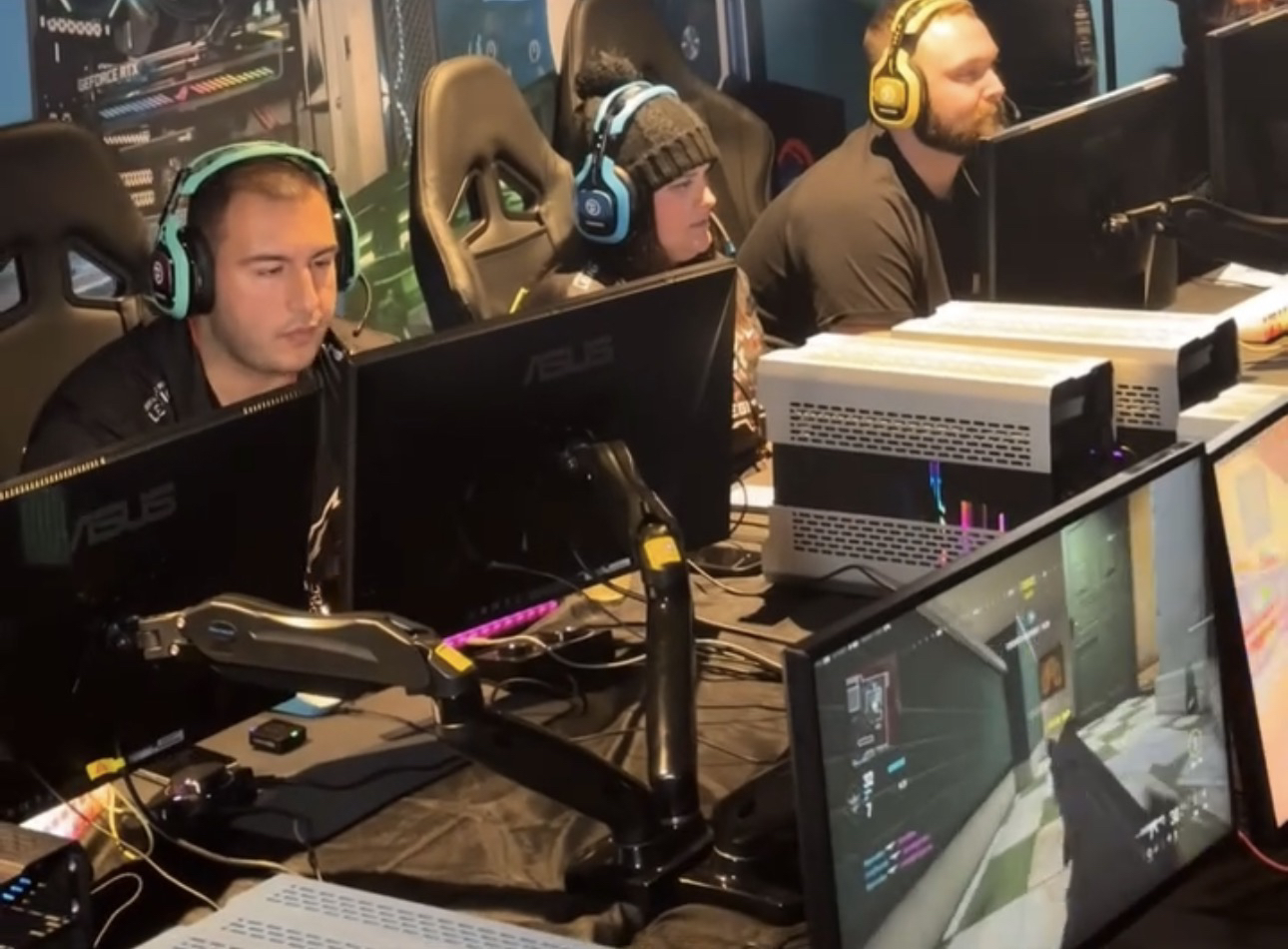 Jugadores frente a monitores en un torneo de videojuegos