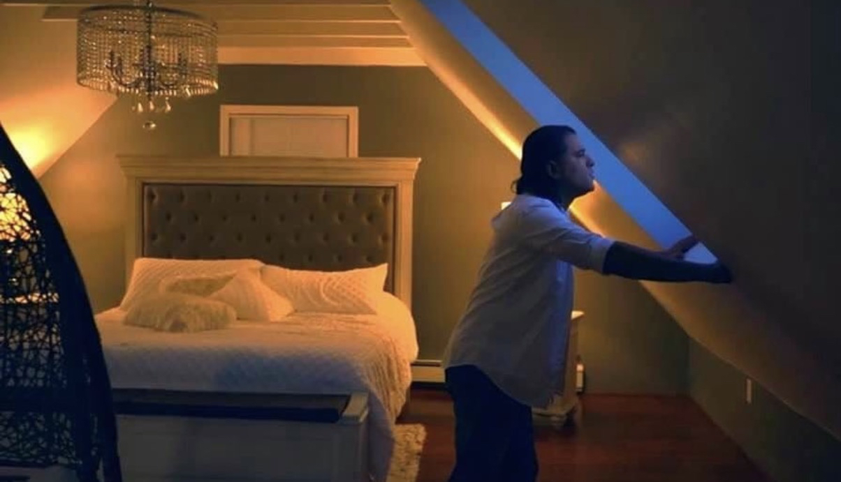 Domenic Marte en una habitación iluminada, durante la grabación de un video musical