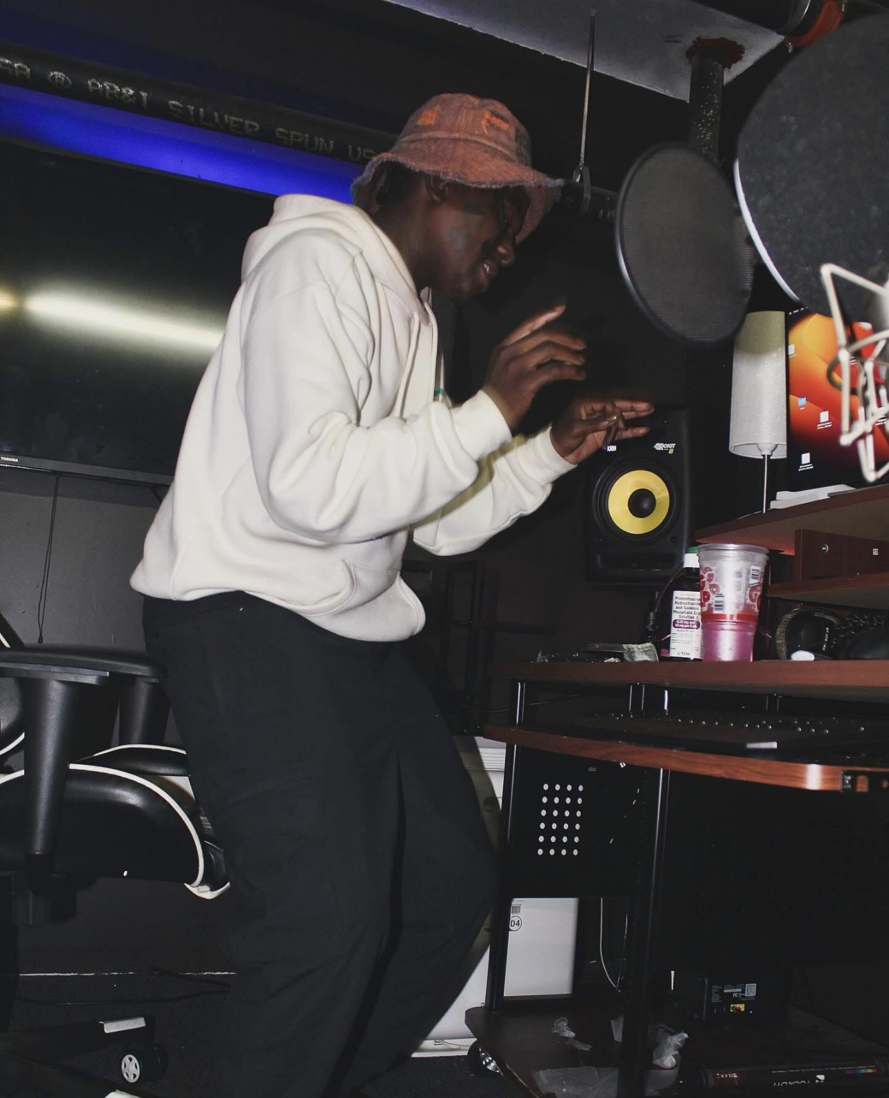 Trae Da Kidd moviéndose frente a un micrófono en una cabina de estudio