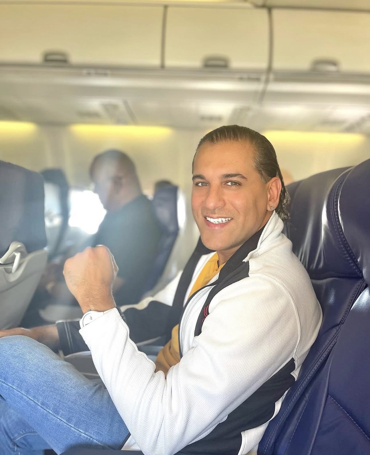 Domenic Marte sonriendo en un asiento de avión