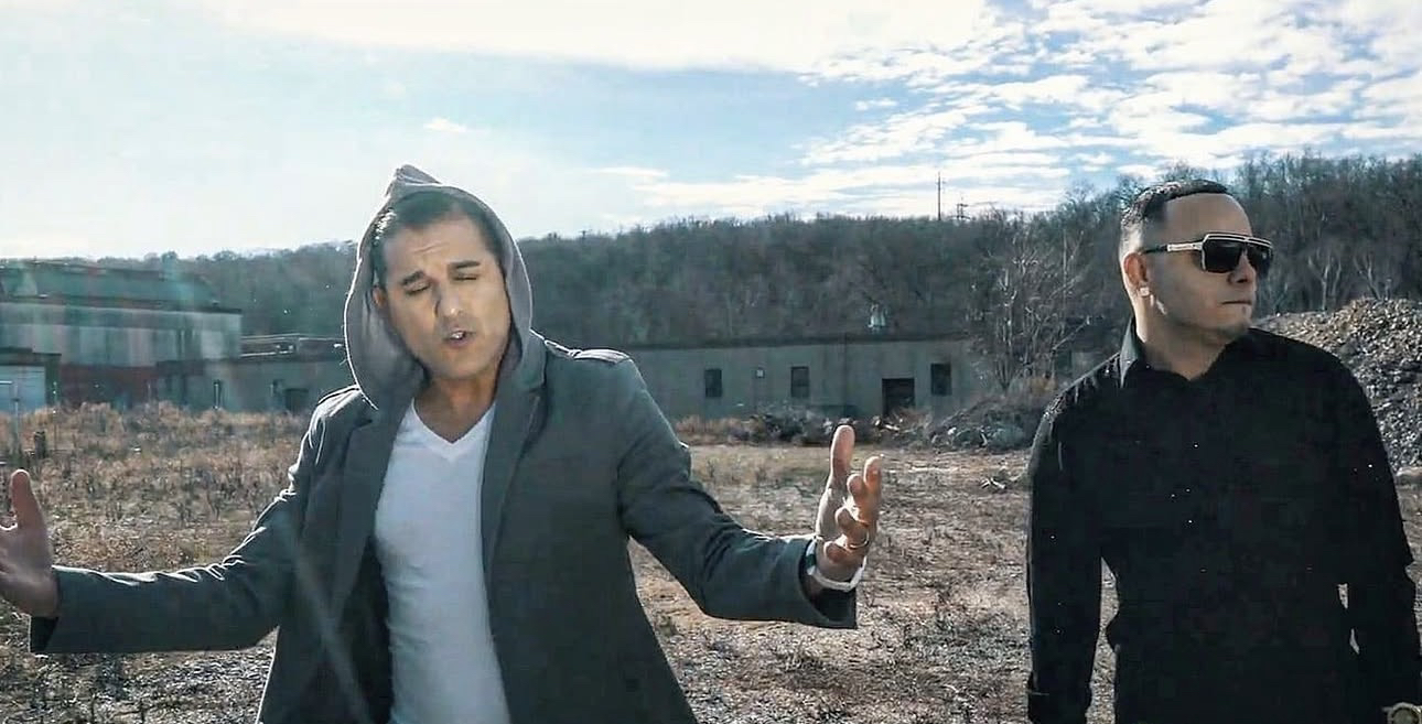 Domenic Marte y otra persona en un exterior, durante la grabación de un video musical