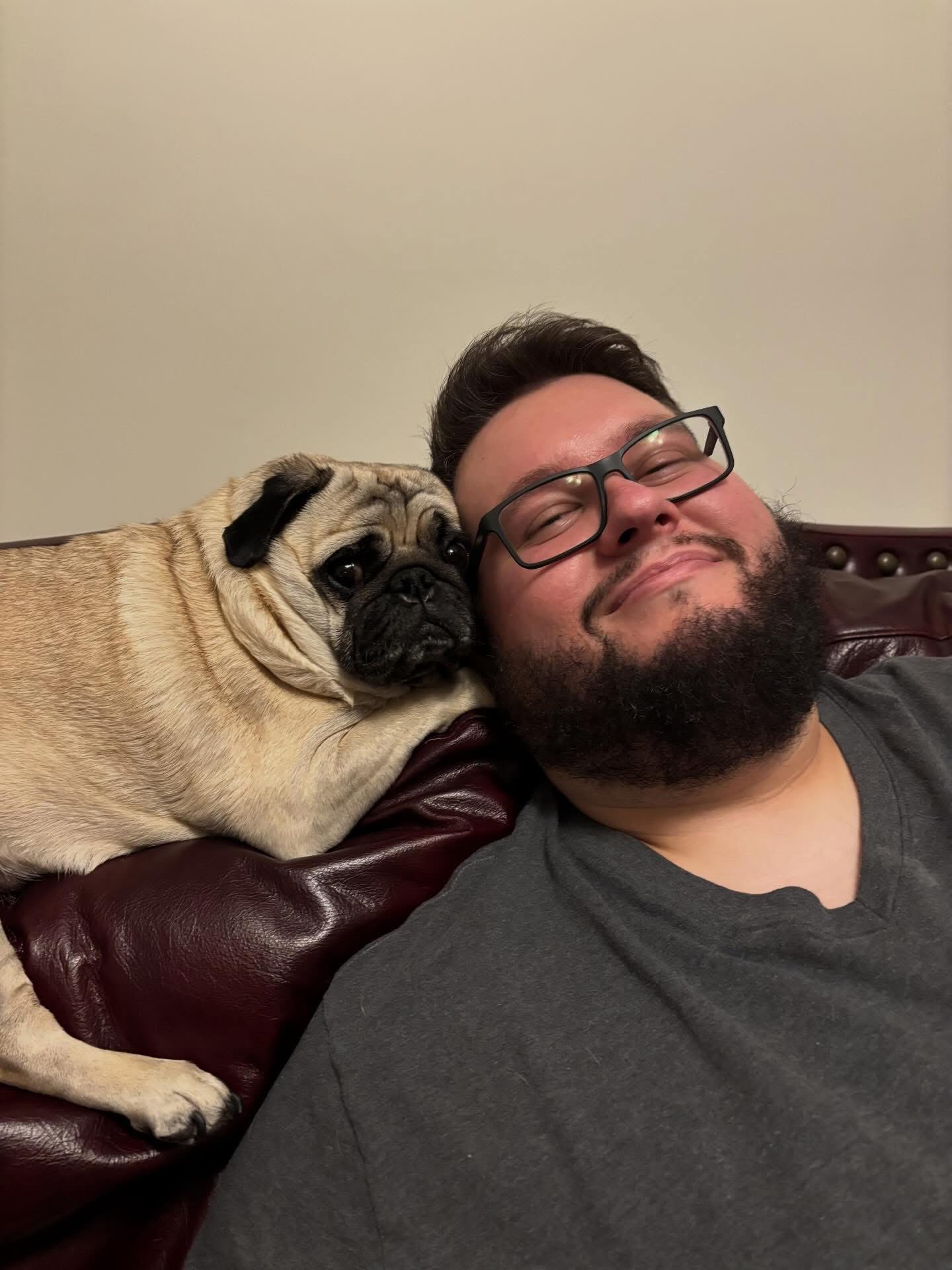 Flats junto a su perro, un pug, en un sofá