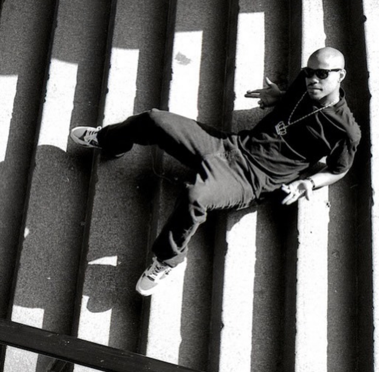 Guru reclinado contra una pared, con lentes de sol