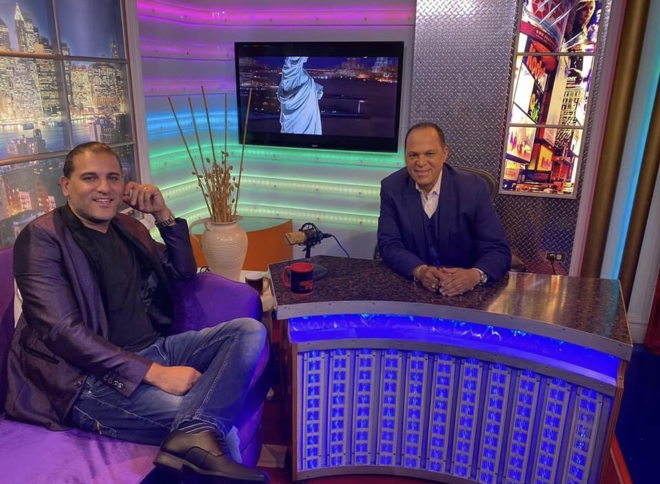 Domenic Marte entrevistado en un set de televisión, junto al presentador