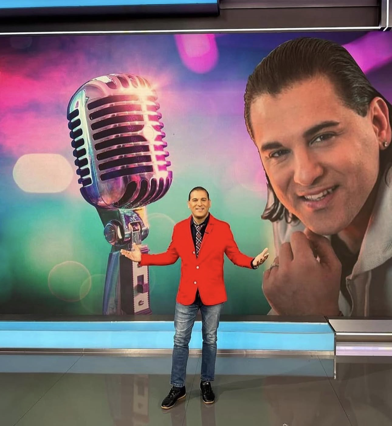 Domenic Marte en un estudio de televisión, frente a una gráfica con un micrófono