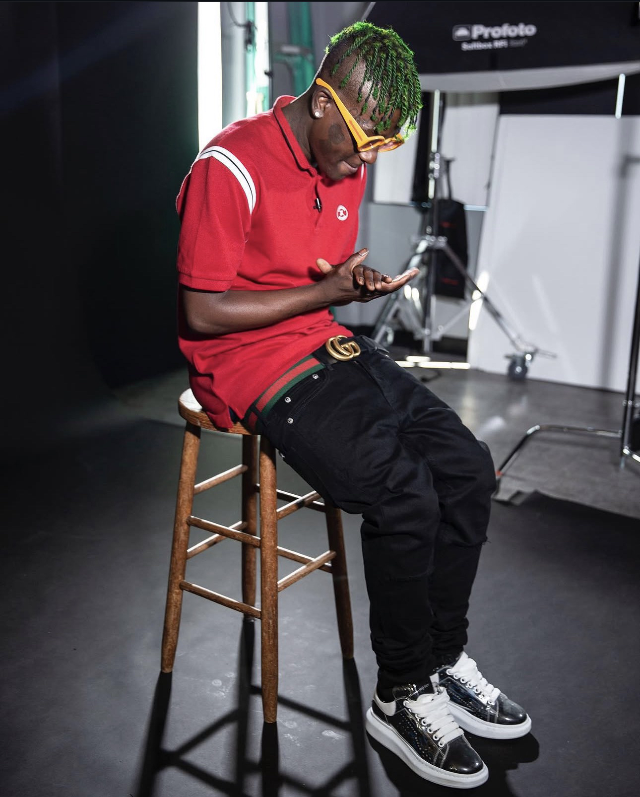 Trae Da Kidd sentado en un taburete dentro de un set de producción