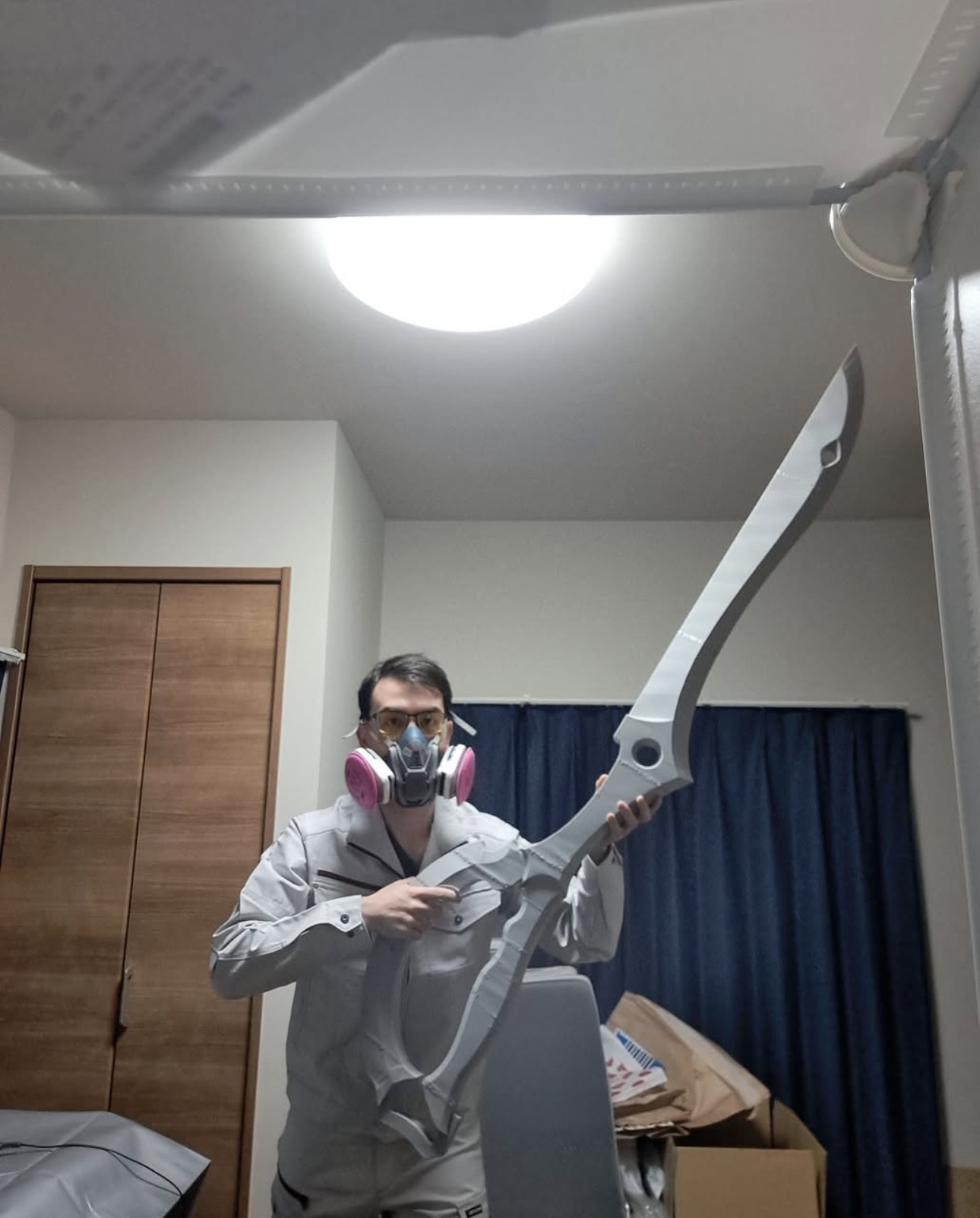 CaptainBryan con una máscara respiratoria, sosteniendo una réplica de espada