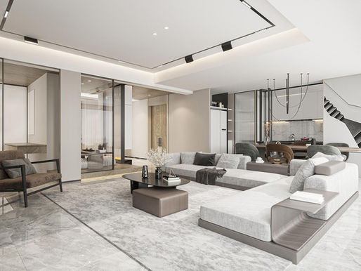 Modern living room with gray sectional, coffee table, armchair, and open kitchen beside a staircase.