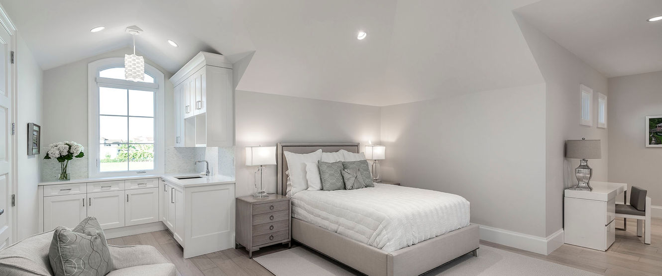 In-law suite bedroom featuring private sitting area, built-in cabinetry, and comfortable residential layout