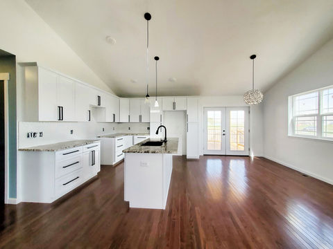 Oxford Kitchen. Island sink, Marble counter tops, pendant lighting, natural oak floors, and French doors.
