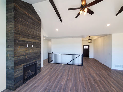 Fitzgerald Living Room. Open concept, LVP wood floors, vaulted ceiling, gas fireplace, shiplap accent wall.