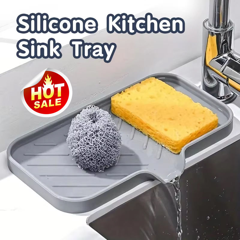 Gray silicone kitchen sink tray holding a sponge and scrubber