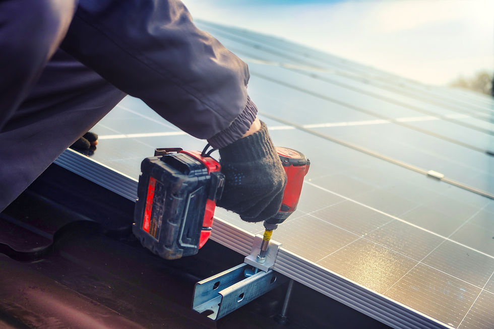 Solar installer tightening a bonding clamp on an aluminum PV racking rail for solar panel grounding