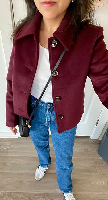 Denim jeans, tennis shoes, black crossbody bag, white t-shirt, gold earrings, cropped coat