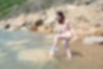 Hula hoop performer, Laura Loops, posing naked in the sea at Fairlight Cove naturist beach near Hastings