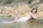 Hula hoop performer, Laura Loops, posing naked in the sea at Fairlight Cove in East Sussex
