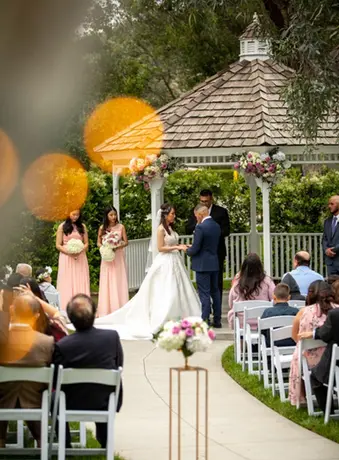 utilizing twinkle lights to create orbs as the couple gets married under a gazeebo