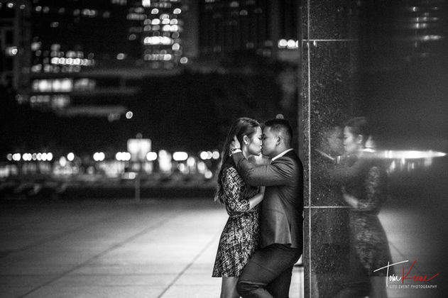 Engagement photo: Couple kissing at night with city lights