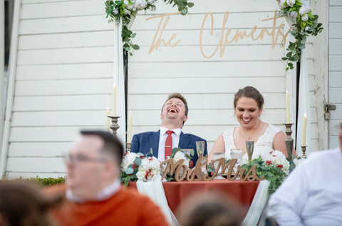 candid of groom and bride laughing from the best man's speech