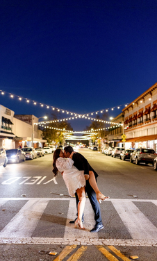 Engagement photo on street at night with string lights