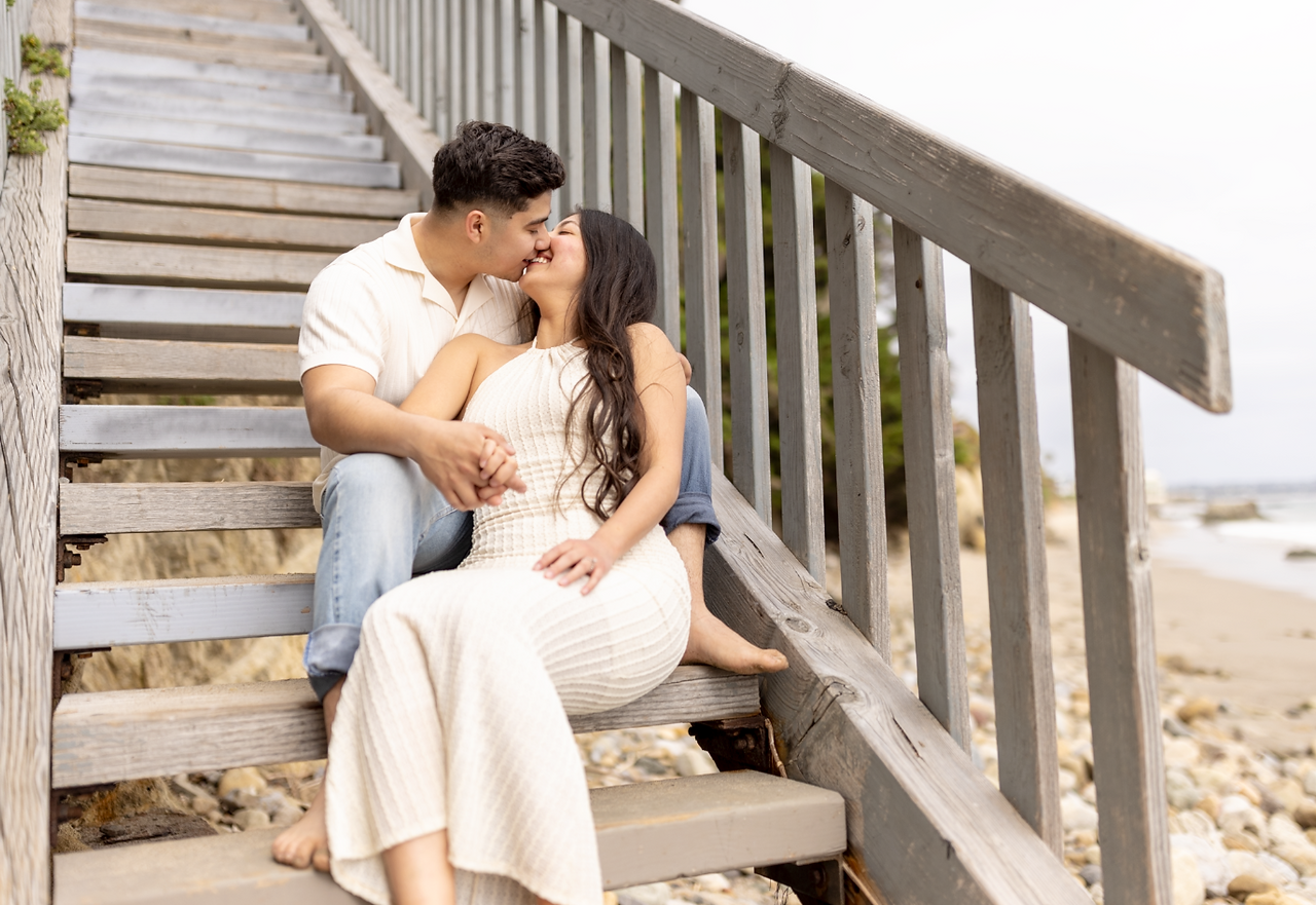 Engaged couple kissing on outdoor stairs