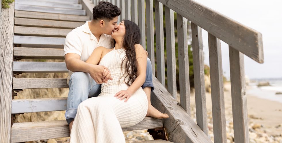 Engaged couple kissing on outdoor stairs