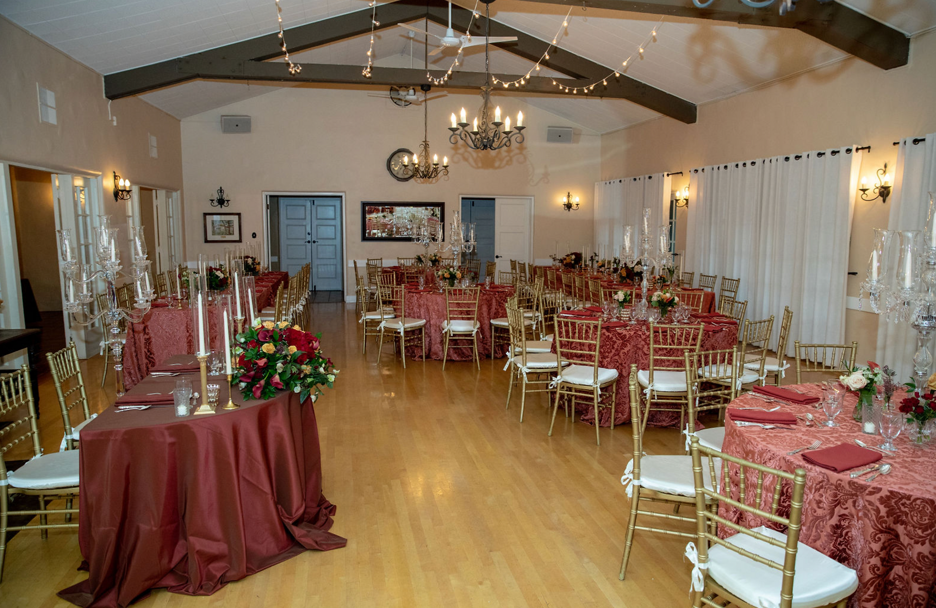 Event hall set with tables, red cloths, gold chairs