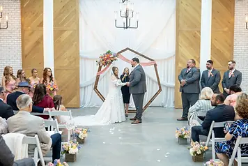Indoor wedding ceremony with bride, groom, and attendees