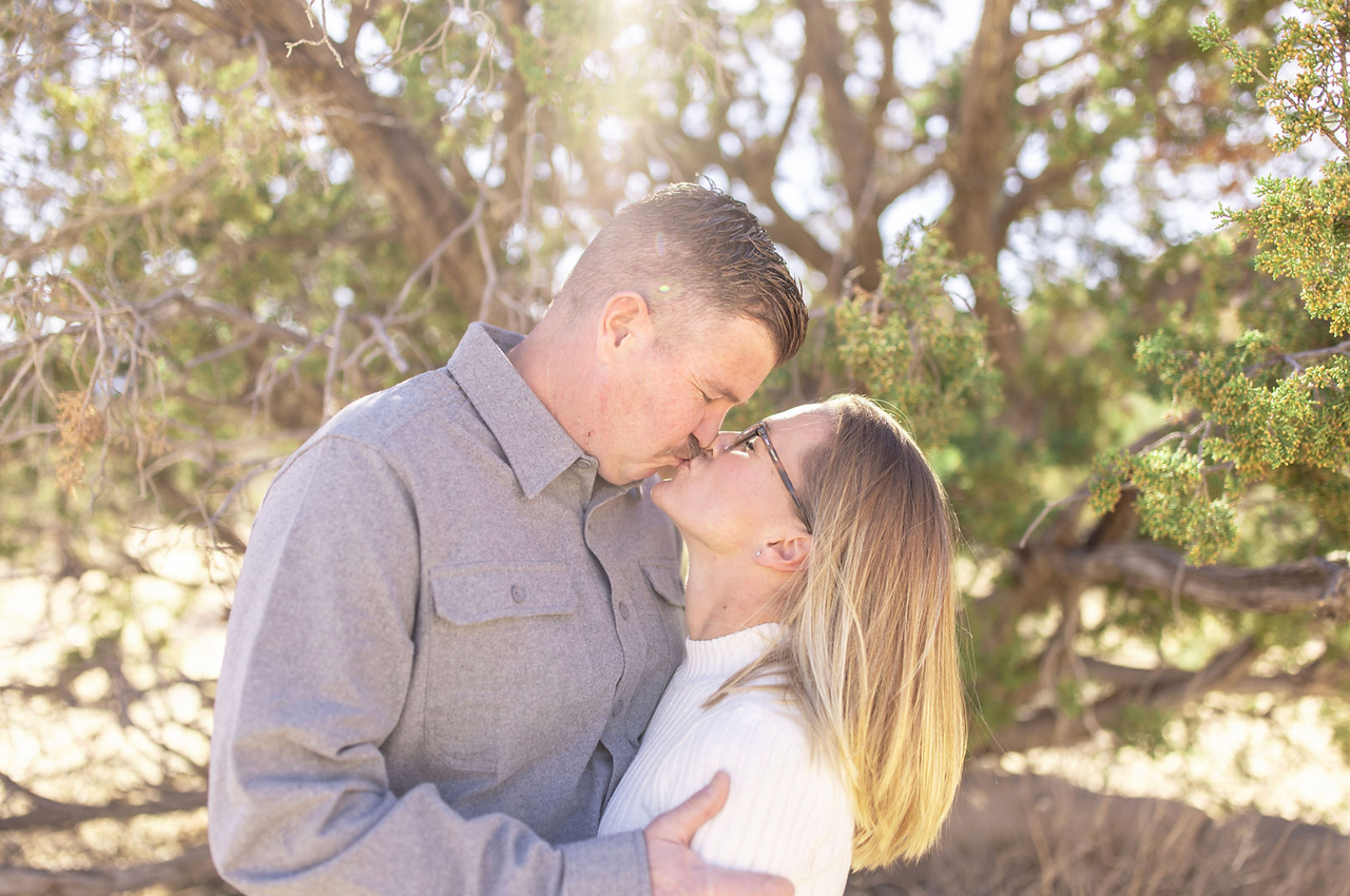 Engagement photo of a couple kissing outdoors