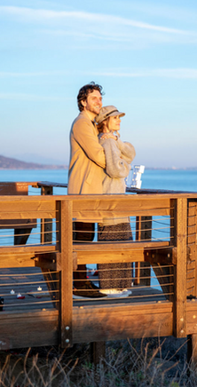 Couple on scenic ocean overlook, an ideal engagement photo location.
