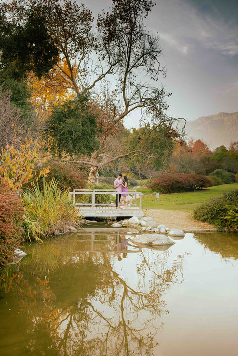 couple on bridge during their engagement session after he proposed
