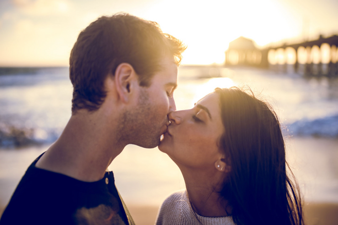 Couple kissing at sunset, an Orange County engagement photo location.