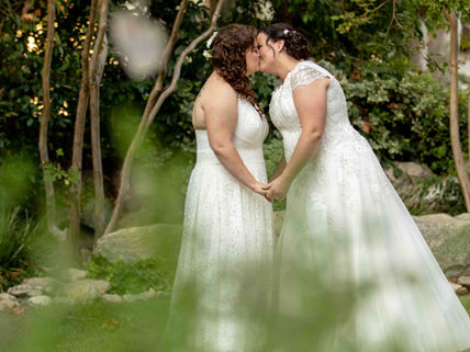 LGBTQ couple kissing in a private moment after their ceremony