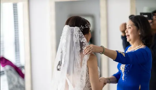 mom helps the bride get ready before ceremony
