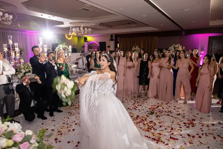 Bride throwing bouquet to wedding guests