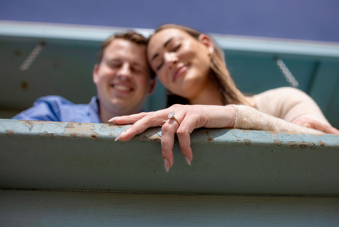 Engagement photo of couple with prominent ring on a ledge