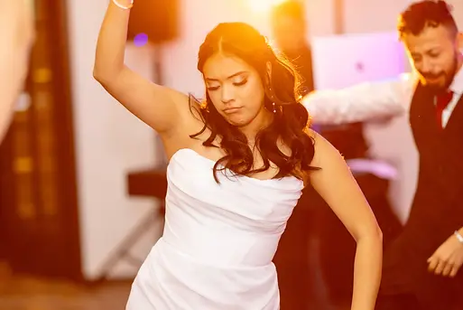 Bride dances on the dance floor with DJ behind