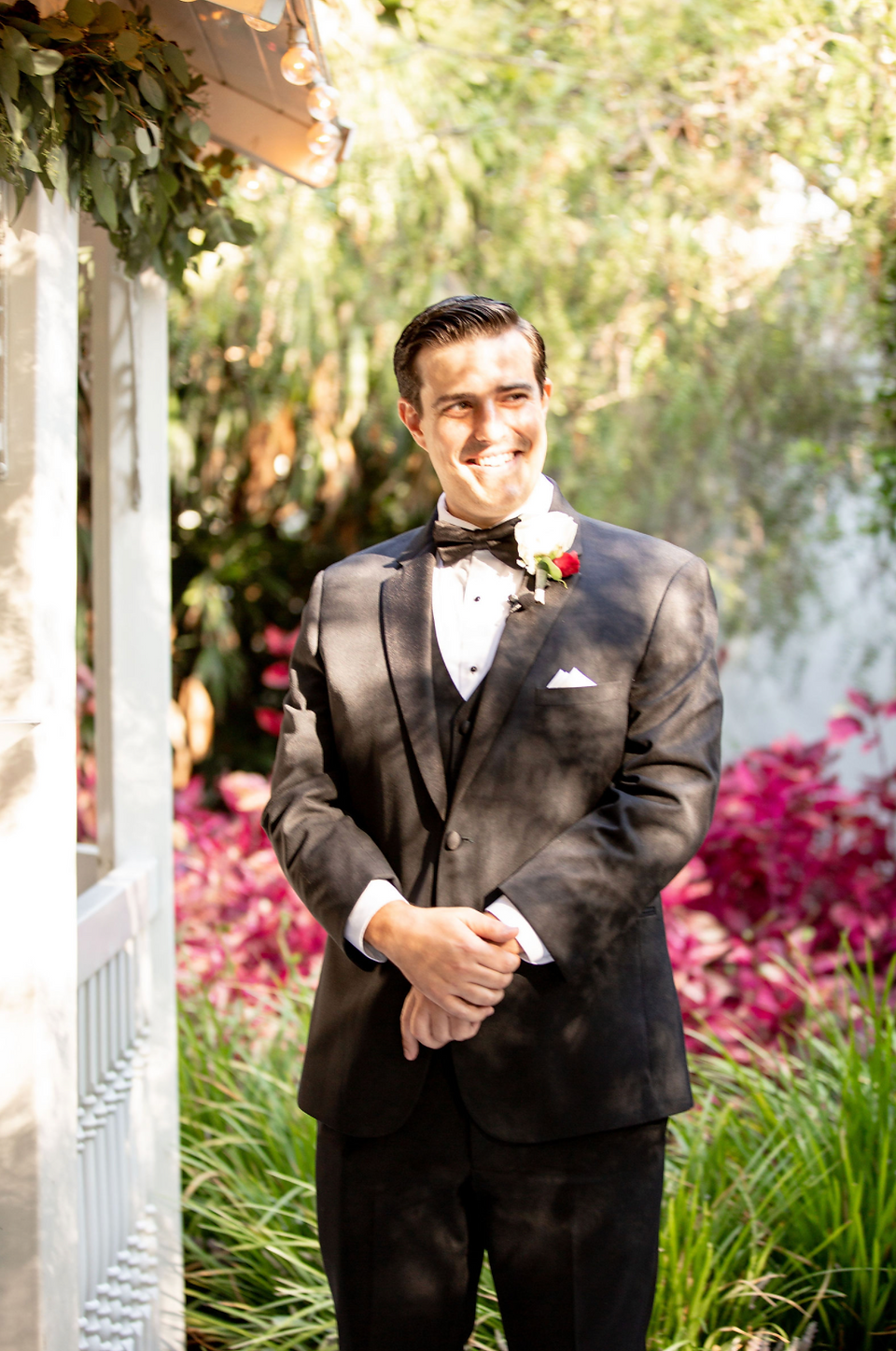 Groom in black tuxedo smiling outdoors at Grace Hills Ranch