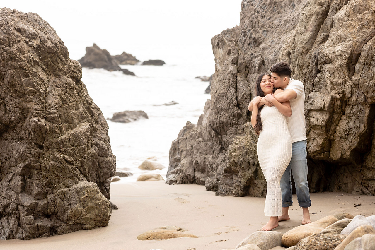 Romantic engagement photo on a rocky beach