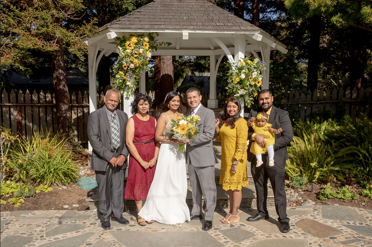Wedding family portrait in front of a floral gazebo