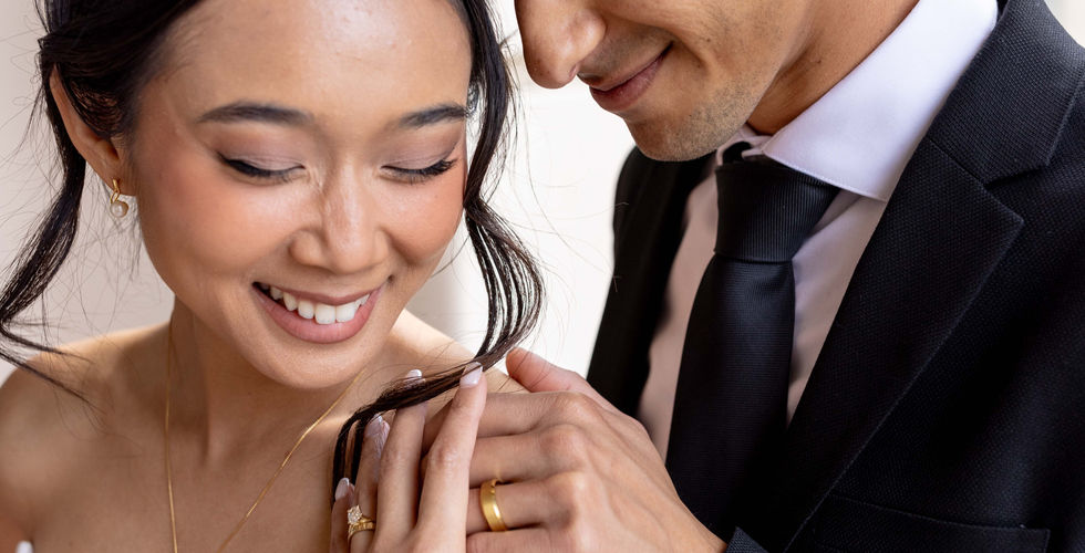 Engaged couple smiling, rings visible