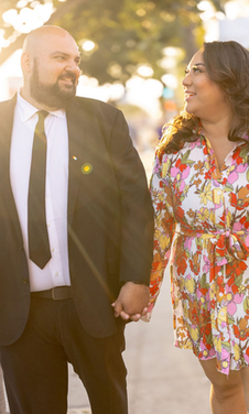 Romantic engagement photo of couple walking at sunset