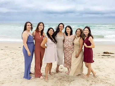 A group of women poses on the beach for a bachelorette party in San Diego.