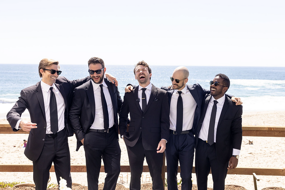 traditional look mens suites at a beach wedding